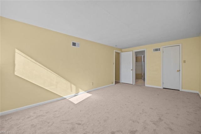 carpeted empty room with baseboards and visible vents