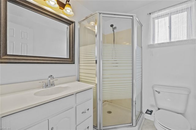 bathroom featuring toilet, vanity, tile patterned floors, and a stall shower