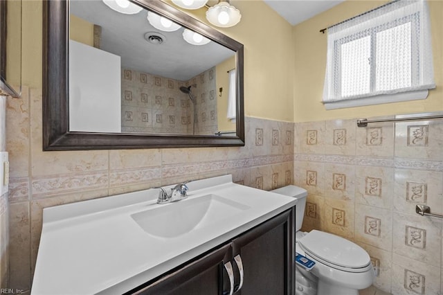 full bath featuring toilet, vanity, visible vents, and tile walls