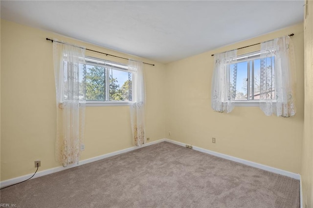 carpeted empty room with baseboards