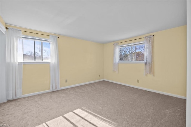 unfurnished room featuring carpet and baseboards