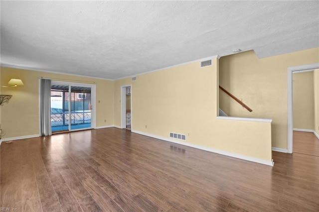 unfurnished living room featuring a textured ceiling, wood finished floors, and visible vents
