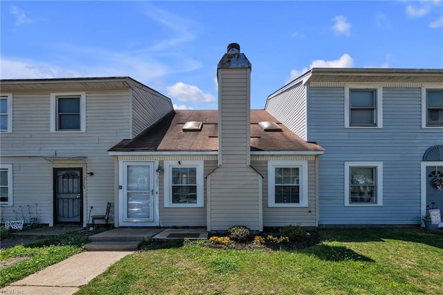 view of front of home with a front lawn and a chimney