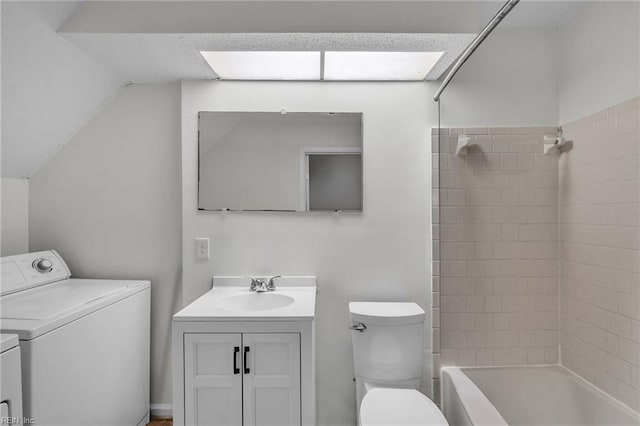 bathroom featuring toilet, vaulted ceiling, vanity, washer and dryer, and shower / tub combination