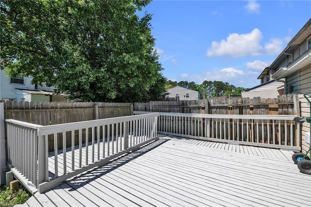 wooden deck with a fenced backyard