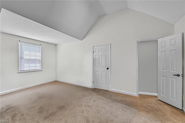interior space featuring vaulted ceiling and baseboards