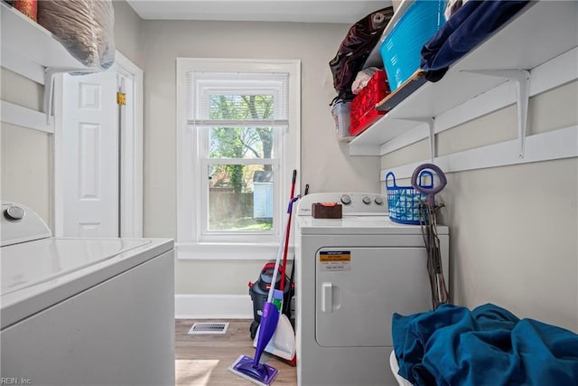 washroom featuring wood finished floors, washer and clothes dryer, laundry area, baseboards, and visible vents