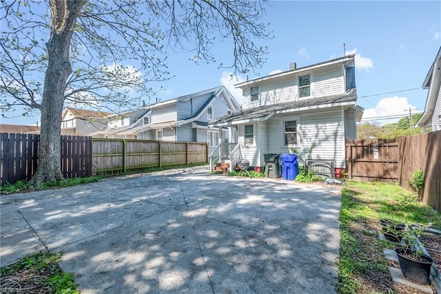 rear view of property with a fenced backyard, a chimney, and a patio