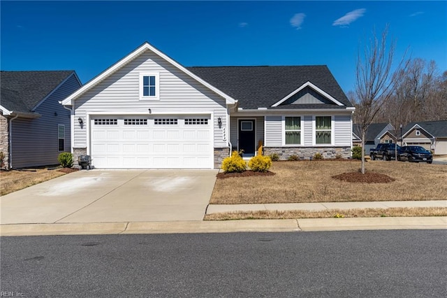 view of front of home featuring concrete driveway, a front lawn, stone siding, a garage, and roof with shingles