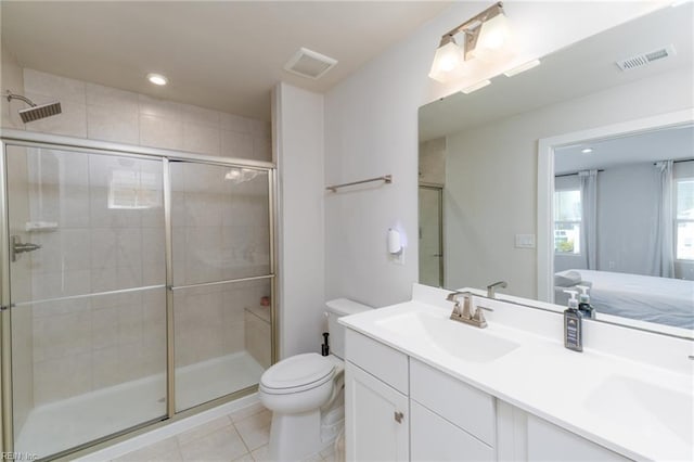 ensuite bathroom with a shower stall, visible vents, toilet, and a sink