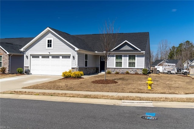 view of front facade featuring stone siding, an attached garage, and driveway