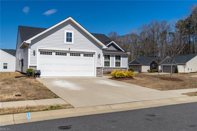 view of front of property featuring concrete driveway, stone siding, and a garage