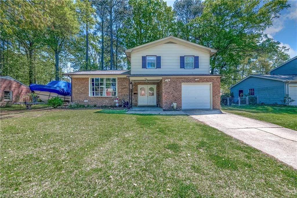 view of front of house with brick siding, a front lawn, concrete driveway, and a garage