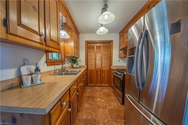kitchen featuring brown cabinets, light countertops, stainless steel appliances, and a sink