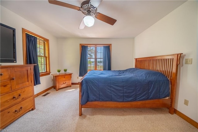bedroom with baseboards, visible vents, light colored carpet, and ceiling fan