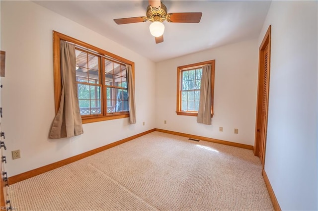 unfurnished room featuring ceiling fan, carpet floors, visible vents, and baseboards