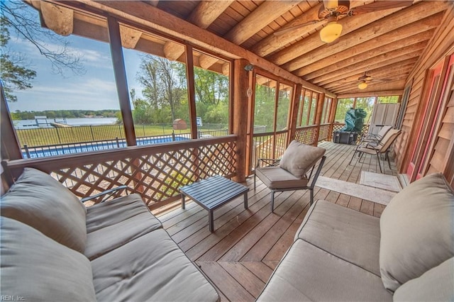 sunroom featuring beamed ceiling and ceiling fan