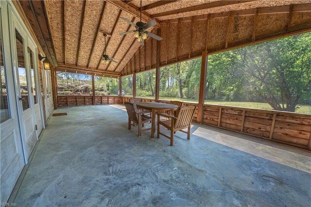 unfurnished sunroom with a ceiling fan and outdoor dining area