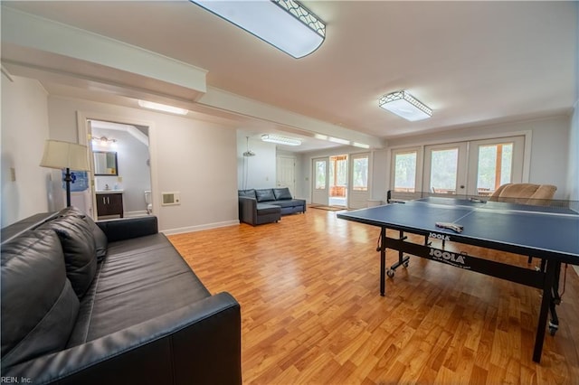 playroom with light wood-type flooring, french doors, baseboards, and ornamental molding