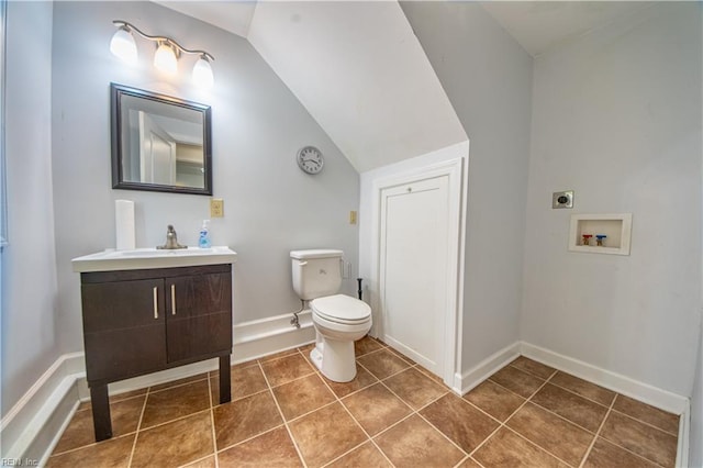 half bathroom featuring tile patterned floors, baseboards, vanity, and toilet
