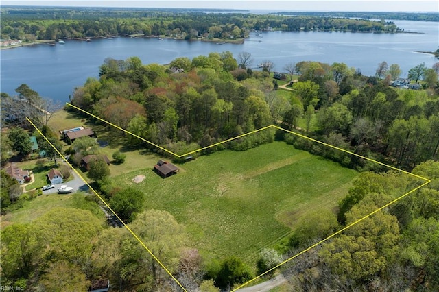 birds eye view of property with a wooded view and a water view