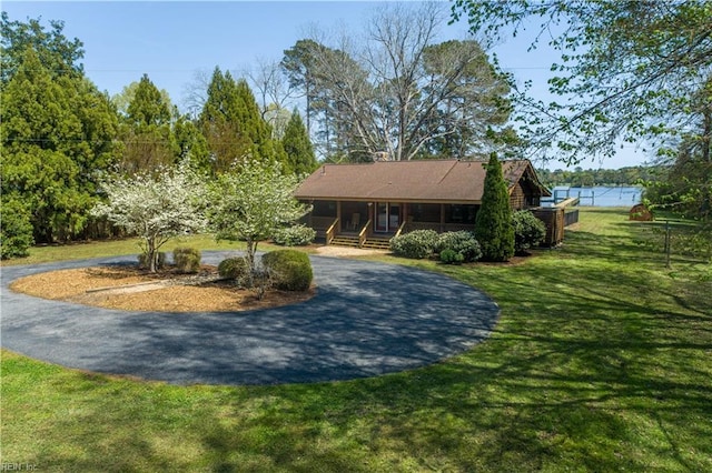 exterior space with a lawn and curved driveway