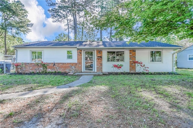 ranch-style home with brick siding and a front yard