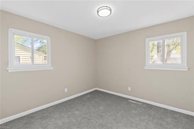 spare room featuring carpet flooring and baseboards