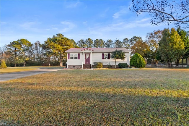 view of front of property with crawl space, driveway, a front lawn, and metal roof
