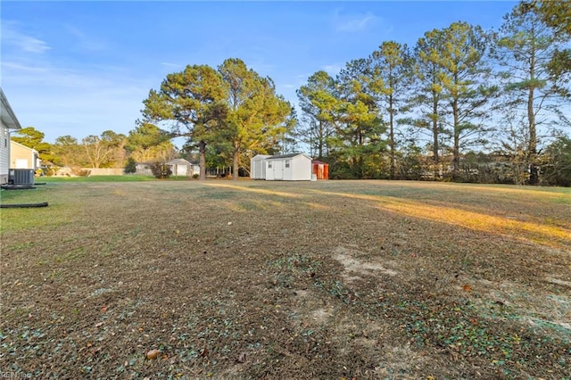 view of yard with an outbuilding, a storage shed, and central AC unit