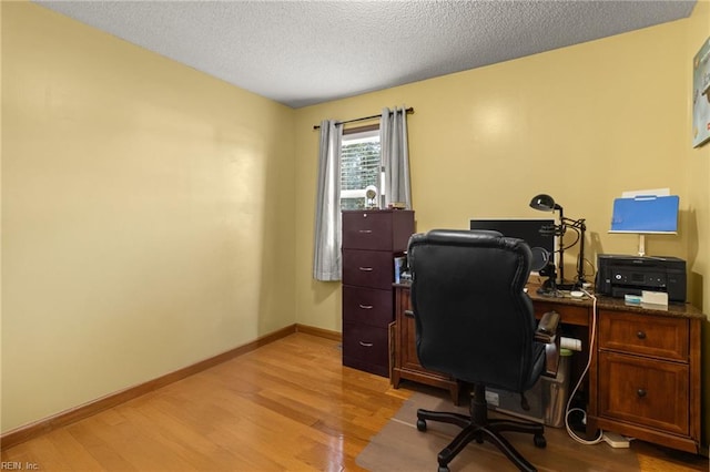 home office with baseboards, a textured ceiling, and light wood-style floors