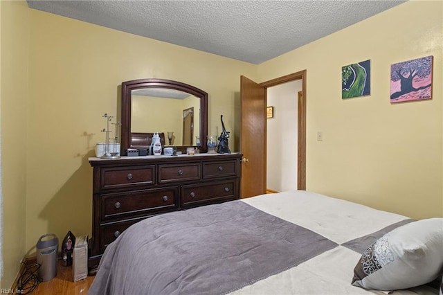 bedroom featuring wood finished floors and a textured ceiling