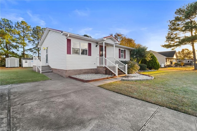 view of front of home featuring driveway, an outbuilding, a storage shed, and a front yard