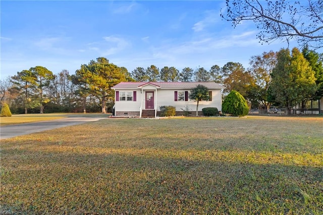 view of front of house featuring a front lawn, crawl space, driveway, and metal roof