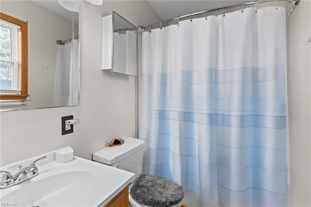 bathroom with toilet, vanity, and a shower with curtain