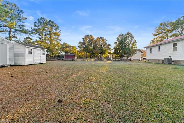 view of yard featuring a shed, fence, an outbuilding, and cooling unit