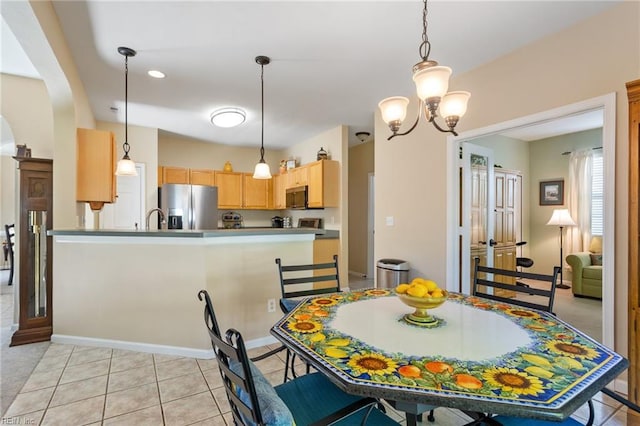 dining area featuring arched walkways, baseboards, a notable chandelier, and light tile patterned floors
