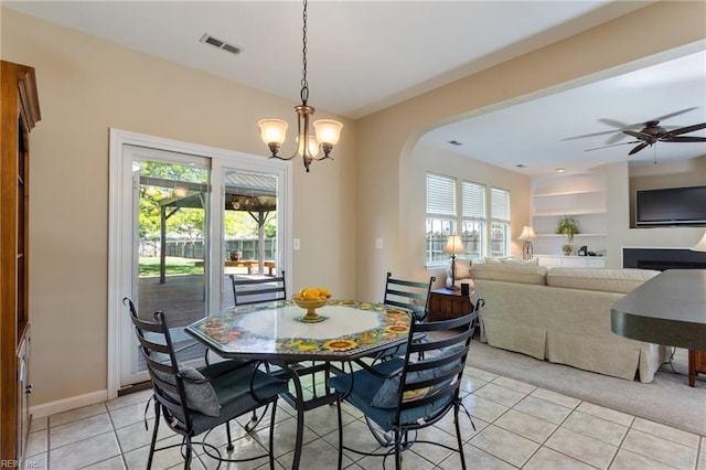 dining room featuring arched walkways, ceiling fan with notable chandelier, visible vents, and light tile patterned floors