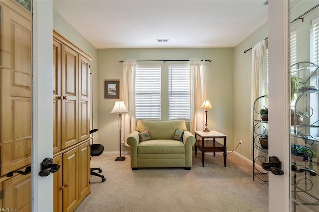 living area with baseboards, visible vents, light colored carpet, and french doors