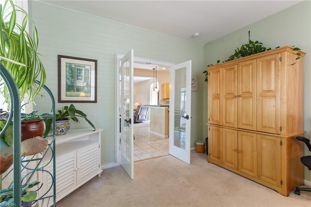 interior space featuring light carpet, french doors, and baseboards