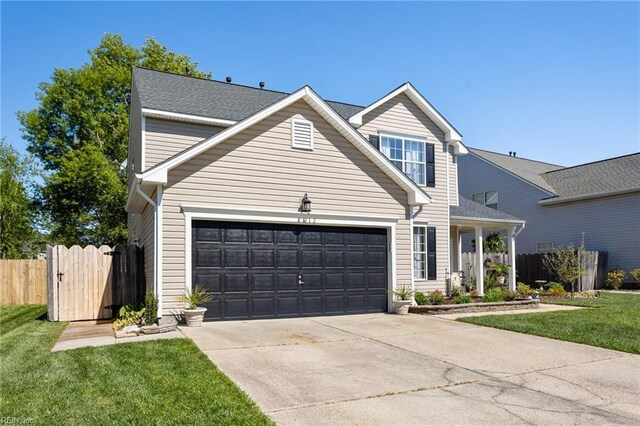 traditional-style house featuring fence, an attached garage, a front yard, and concrete driveway