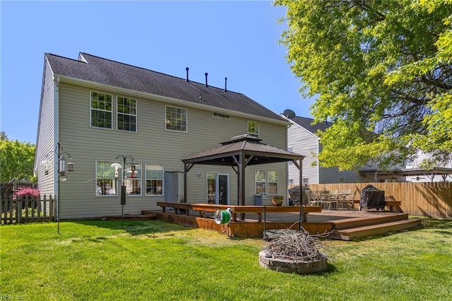 rear view of house featuring fence, a gazebo, a yard, and a deck