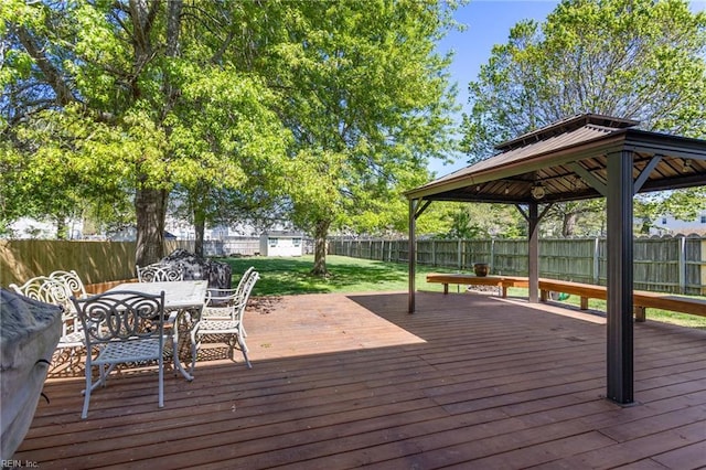 wooden terrace featuring a gazebo, a yard, outdoor dining space, and a fenced backyard