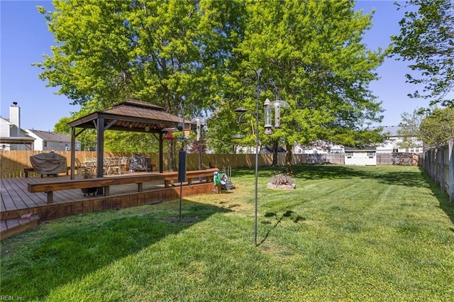 view of yard featuring a gazebo, a wooden deck, and a fenced backyard