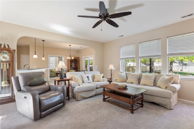 living area with visible vents, arched walkways, and a healthy amount of sunlight