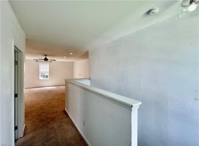 hallway with attic access, carpet, and an upstairs landing
