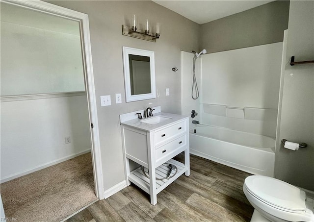full bathroom featuring toilet, wood finished floors, vanity, baseboards, and bathing tub / shower combination