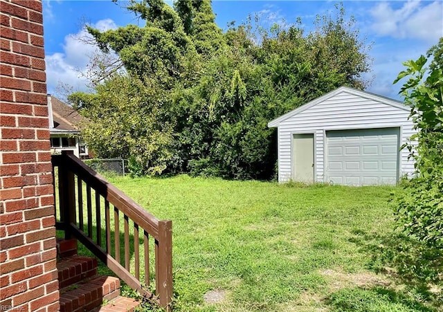 view of yard featuring an outdoor structure, fence, and a garage
