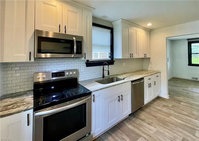 kitchen with white cabinetry, stainless steel appliances, and a sink