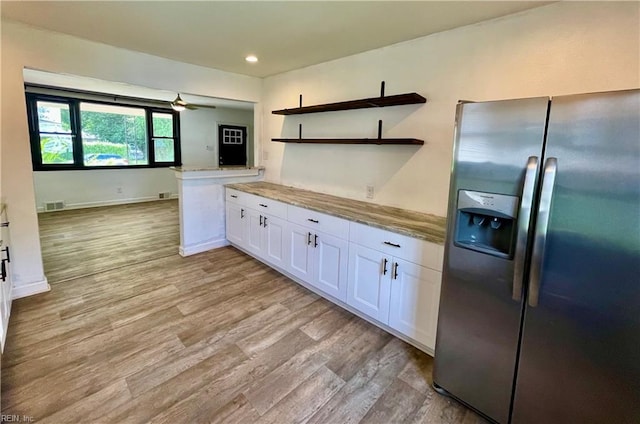 kitchen featuring stainless steel fridge, visible vents, light wood finished floors, and white cabinetry